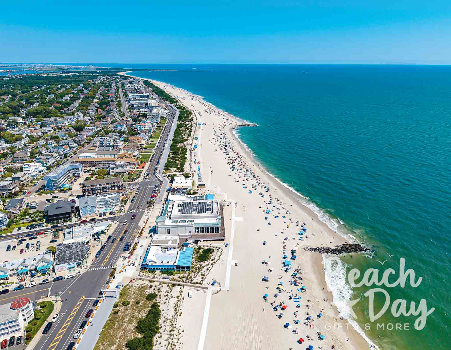 September: Aerial view of Cape May's long sandy beach, ocean, and beachfront buildings