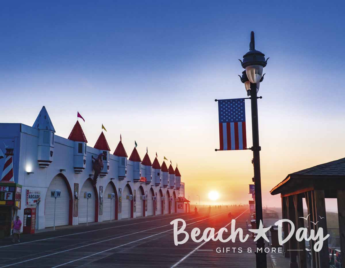 Sunrise over the Ocean City NJ Boardwalk with an American flag and amusement buildings