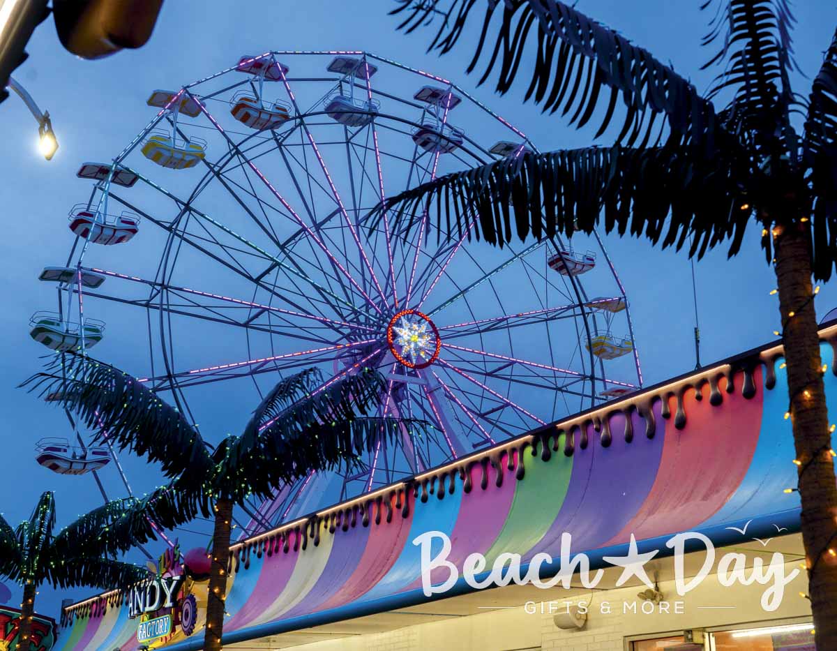 Illuminated Ferris wheel and palm trees on the Ocean City NJ Boardwalk at dusk
